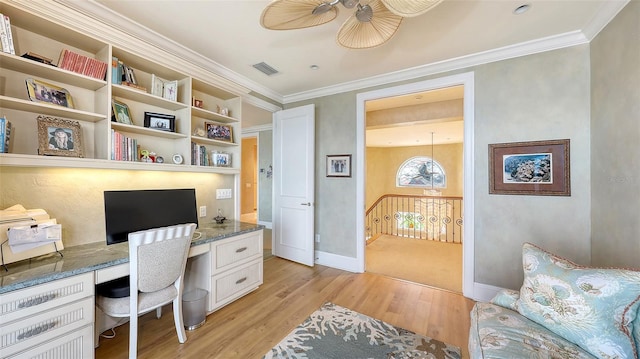 office featuring ornamental molding, built in desk, and light wood-type flooring