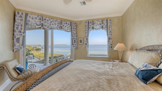 bedroom featuring multiple windows, ornamental molding, and a water view