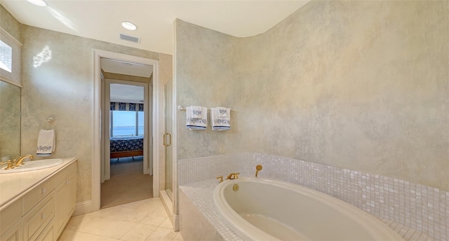 bathroom featuring vanity, tile patterned floors, and tiled bath