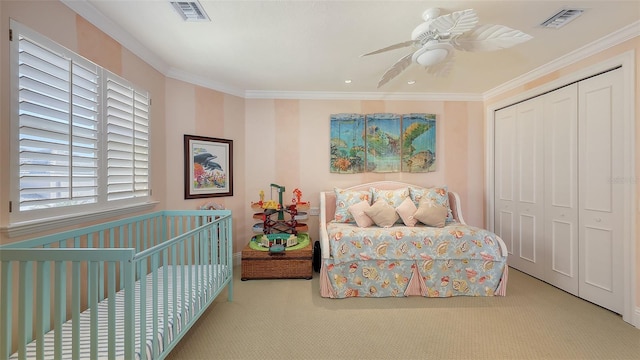 carpeted bedroom featuring ceiling fan, ornamental molding, and a closet