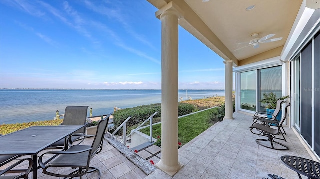 balcony with a water view, ceiling fan, and a patio