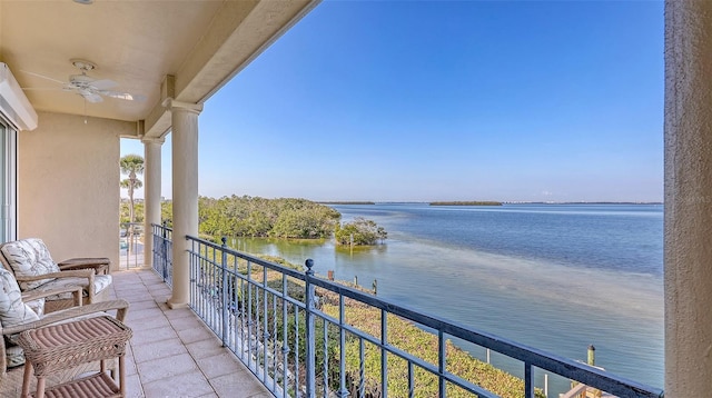 balcony featuring a water view and ceiling fan