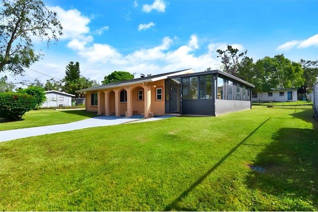 view of front of property with a sunroom and a front yard