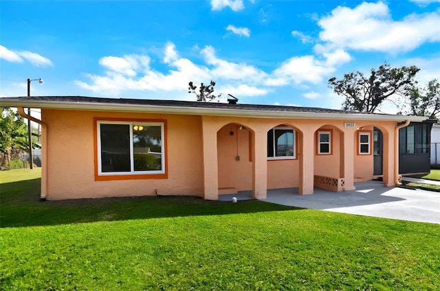 view of front of house with a front lawn and a patio