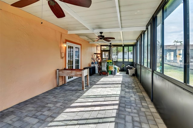 unfurnished sunroom with beam ceiling and ceiling fan