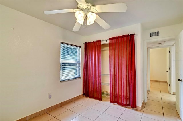 tiled empty room with ceiling fan