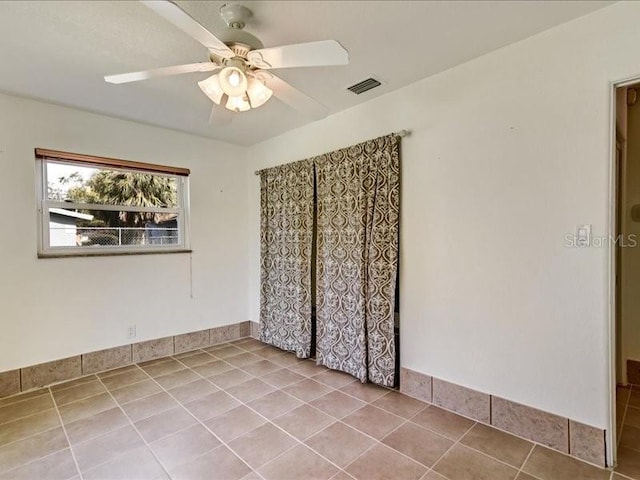 unfurnished room with light tile patterned floors and ceiling fan