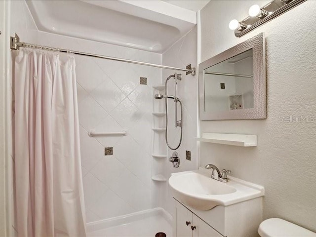 bathroom with vanity, toilet, and walk in shower