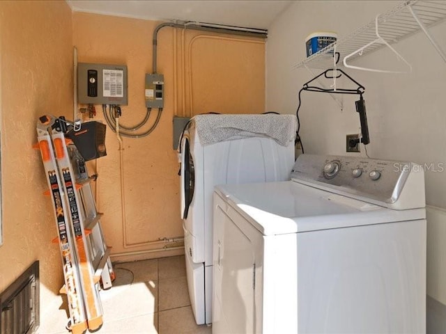 washroom featuring washing machine and dryer and light tile patterned floors