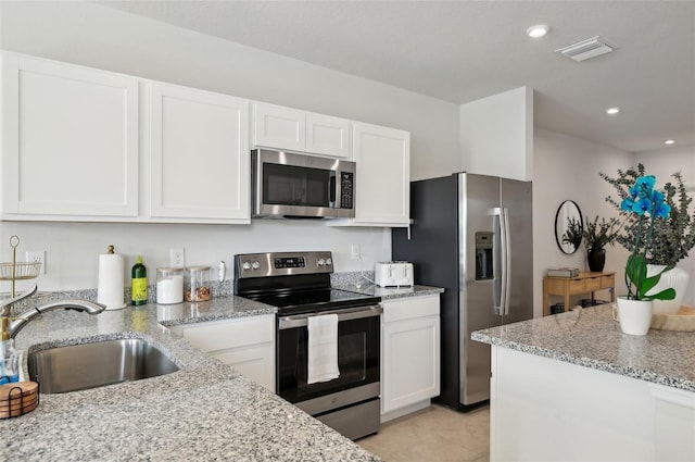 kitchen featuring white cabinetry, appliances with stainless steel finishes, sink, and light stone counters