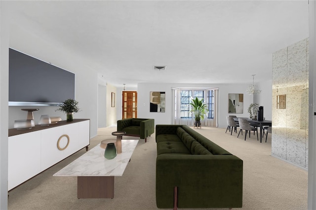 carpeted living room with a notable chandelier