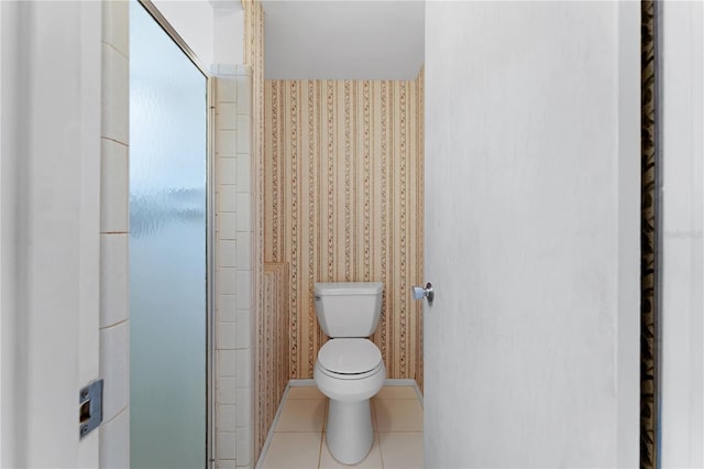 bathroom featuring a shower with shower door, tile patterned floors, and toilet