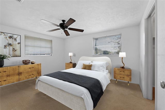 carpeted bedroom with ceiling fan and a textured ceiling