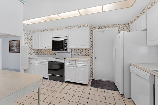 kitchen featuring electric stove, white cabinetry, white dishwasher, and light tile patterned floors