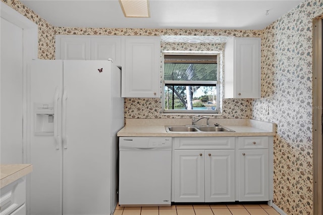 kitchen with sink, light tile patterned floors, white cabinets, and white appliances