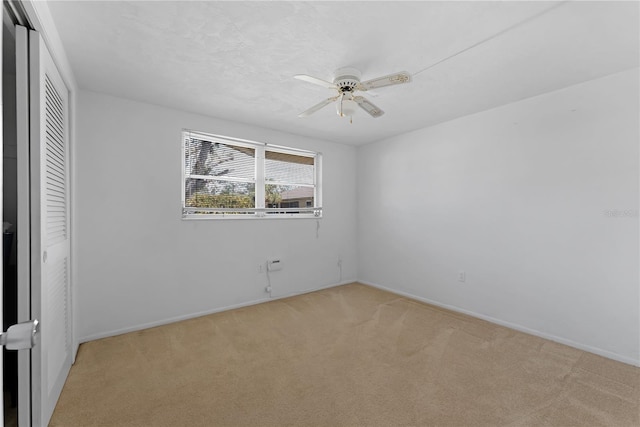 unfurnished bedroom with light colored carpet, a closet, and ceiling fan