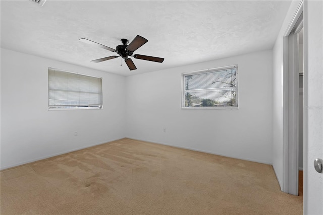 carpeted empty room featuring ceiling fan and a textured ceiling