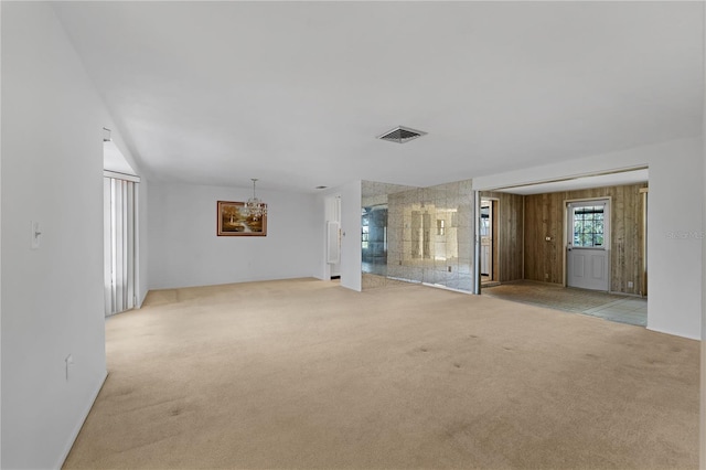 empty room with a chandelier and light carpet