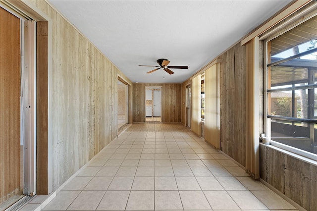 hall with light tile patterned floors and wooden walls