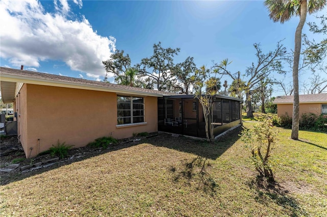 rear view of property with a yard and a sunroom