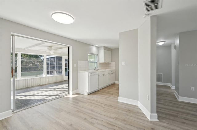 kitchen with dishwasher, backsplash, white cabinets, ceiling fan, and light wood-type flooring