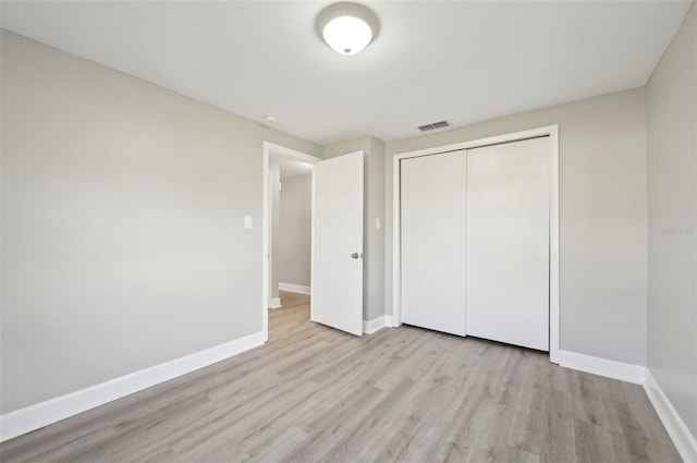 unfurnished bedroom with a closet and light hardwood / wood-style flooring