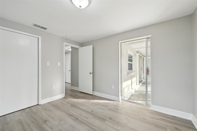 unfurnished bedroom with ensuite bath and light hardwood / wood-style flooring