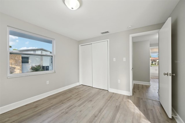 unfurnished bedroom featuring a closet and light hardwood / wood-style flooring