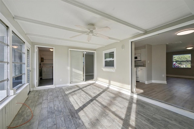 interior space with beam ceiling, washer / dryer, wood-type flooring, and ceiling fan