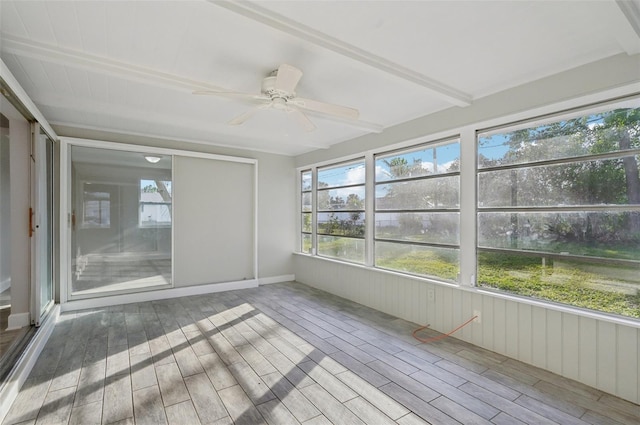 unfurnished sunroom with ceiling fan and beam ceiling