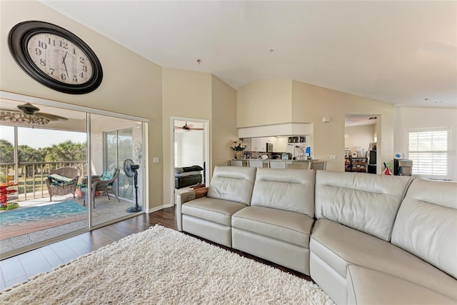 living room with hardwood / wood-style flooring, vaulted ceiling, and ceiling fan