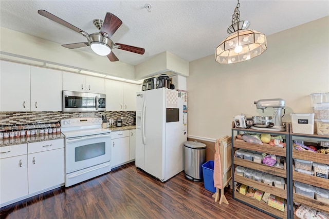 kitchen featuring dark wood-type flooring, tasteful backsplash, hanging light fixtures, white appliances, and white cabinets