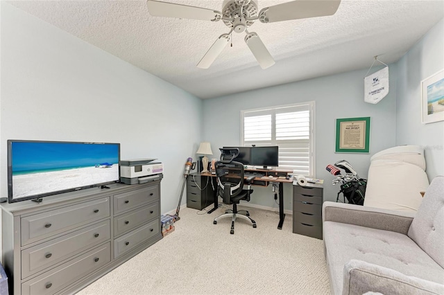 office featuring light carpet, ceiling fan, and a textured ceiling