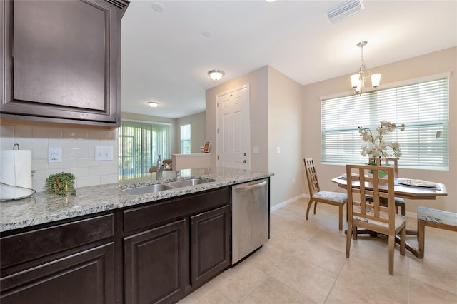 kitchen with tasteful backsplash, sink, hanging light fixtures, stainless steel dishwasher, and dark brown cabinetry