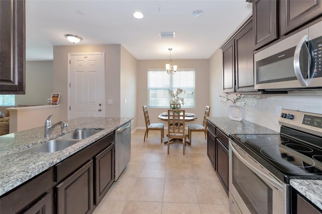 kitchen with appliances with stainless steel finishes, tasteful backsplash, sink, hanging light fixtures, and dark brown cabinets