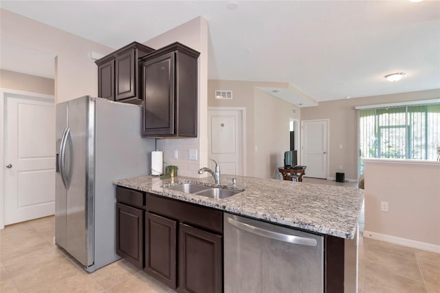 kitchen featuring dark brown cabinetry, stainless steel appliances, sink, and backsplash