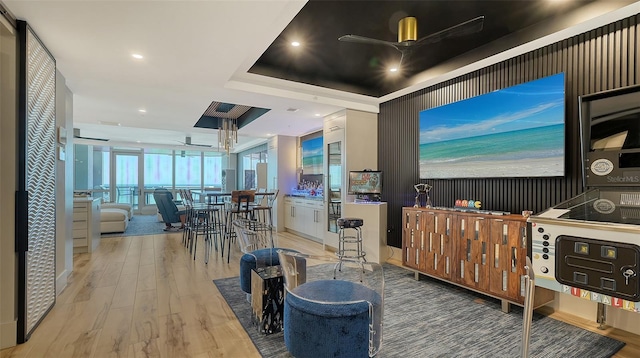 kitchen with ceiling fan, wood-type flooring, a raised ceiling, and white cabinets