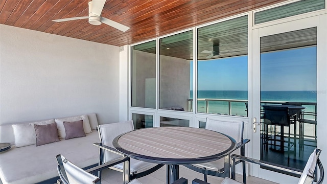 exterior space featuring an outdoor hangout area, ceiling fan, and a water view