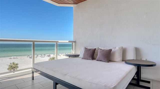 balcony with a water view and a view of the beach