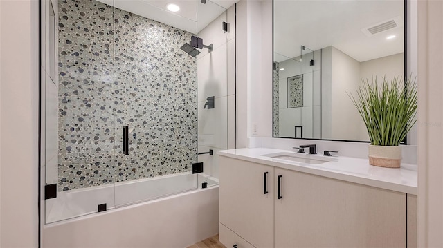 bathroom with vanity and shower / bath combination with glass door