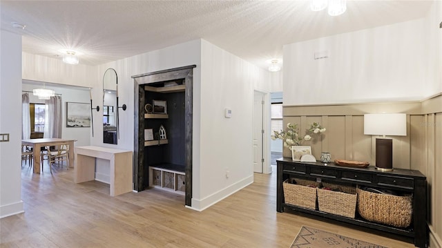 hallway featuring light hardwood / wood-style flooring and a textured ceiling