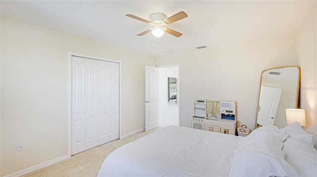 carpeted bedroom with ceiling fan and a closet