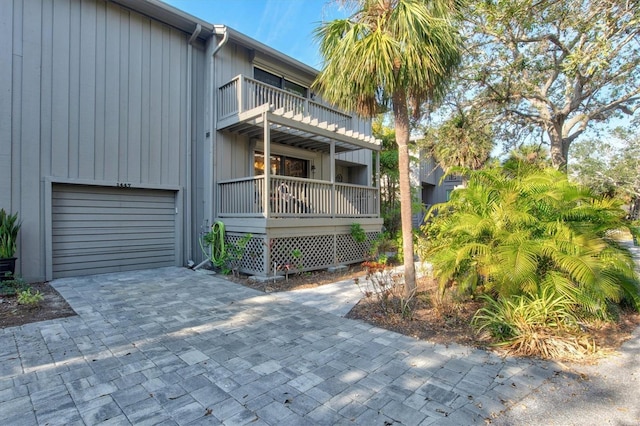 view of side of property featuring a garage and a balcony