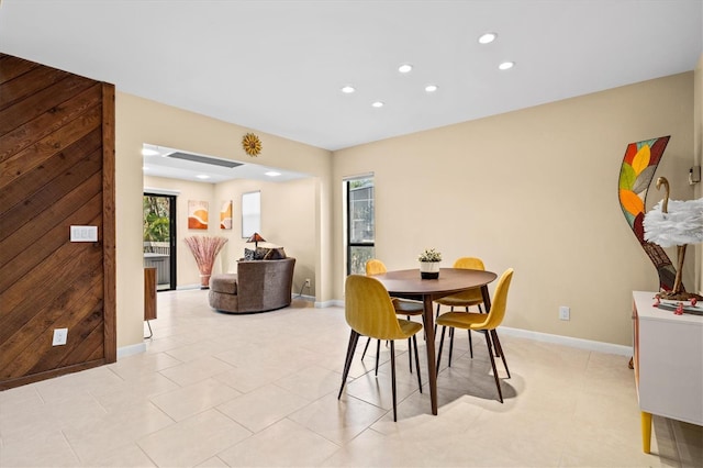 tiled dining room featuring wood walls