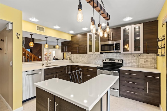 kitchen featuring sink, light tile patterned floors, appliances with stainless steel finishes, hanging light fixtures, and a kitchen island