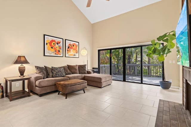 tiled living room featuring ceiling fan and high vaulted ceiling