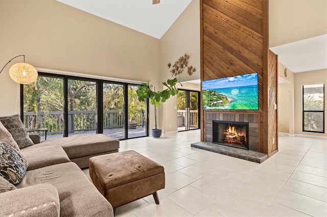 living room featuring high vaulted ceiling, light tile patterned floors, and a fireplace