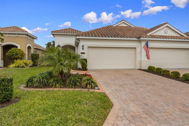 mediterranean / spanish-style house with a garage and a front lawn