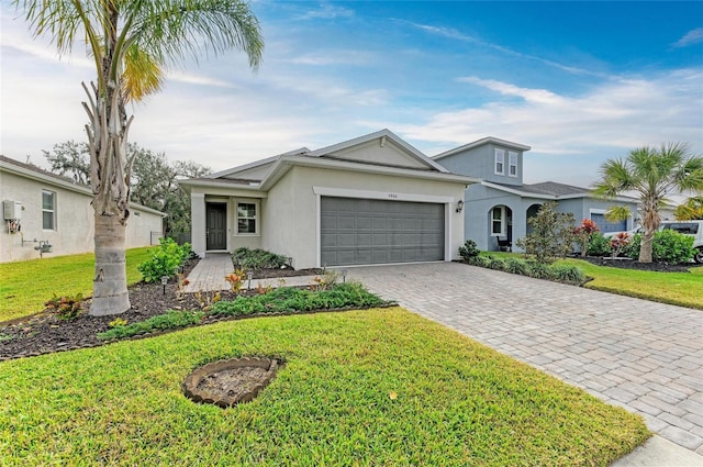 view of front of house featuring decorative driveway, a front yard, an attached garage, and stucco siding