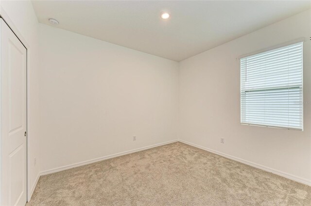 unfurnished room featuring light carpet, recessed lighting, and baseboards